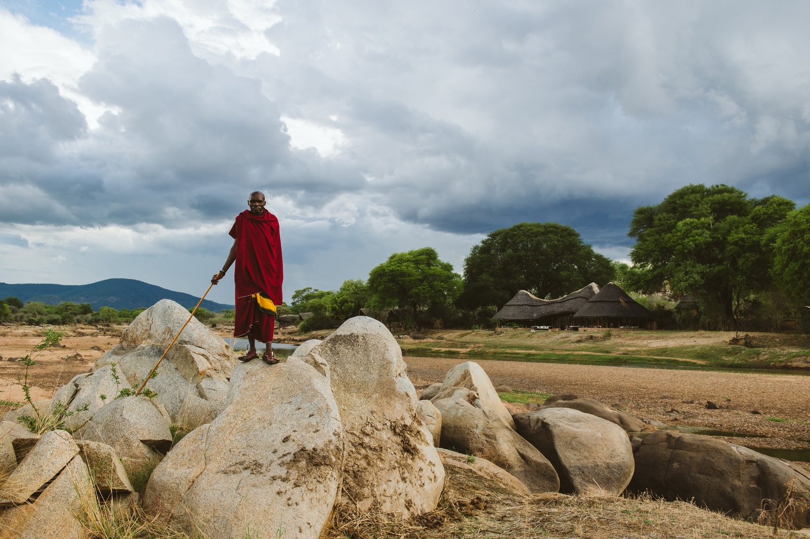 Maasai guide beneath a dramatic East African sky