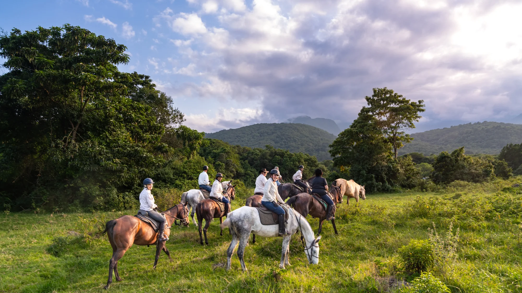 Riders crossing a green highland valley