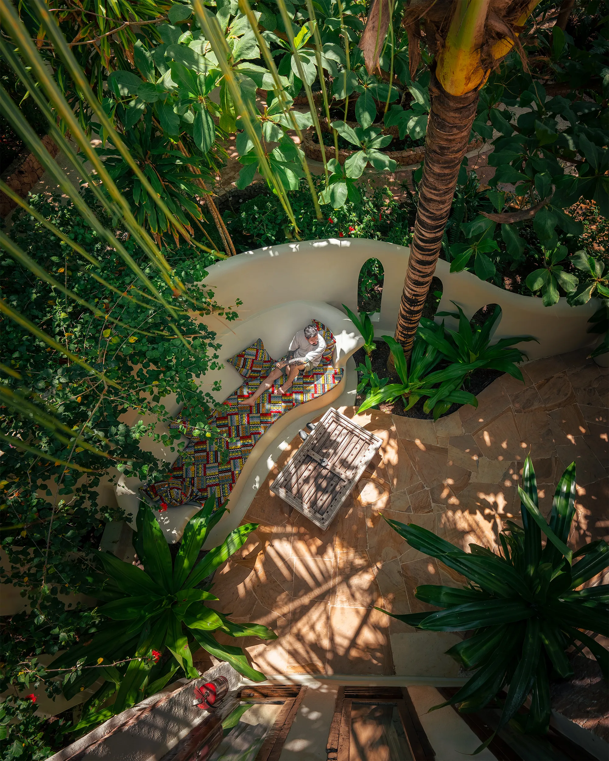 Tropical villa seating curved around a palm tree